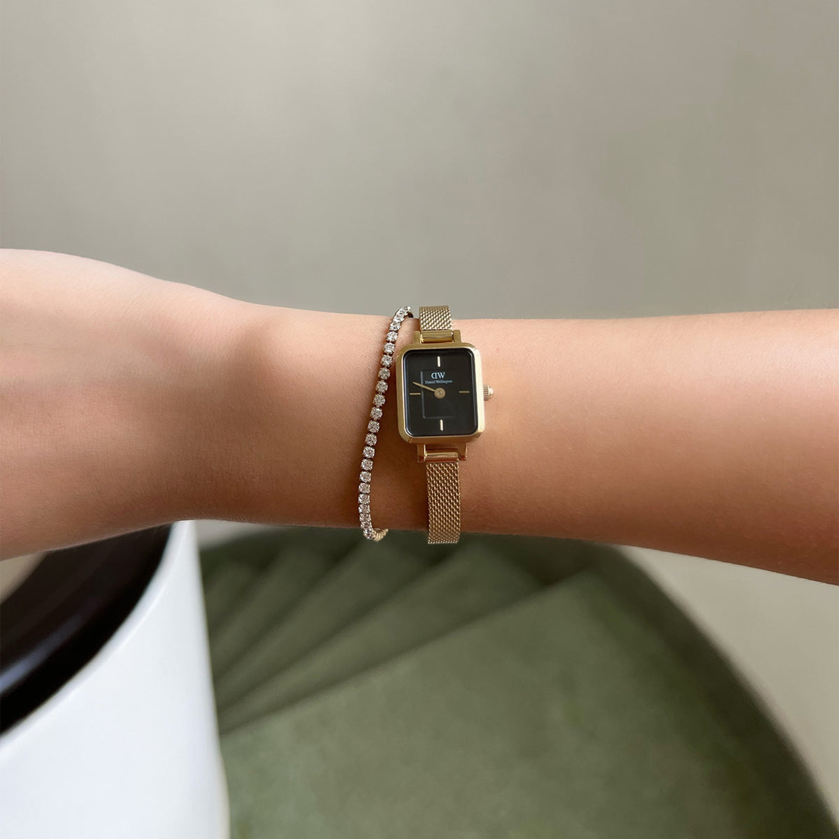 The Quadro Mini Evergold Onyx ladies' watch with a rectangular gold-coloured case, black onyx dial and delicate mesh strap is worn on the wrist together with a sparkling tennis bracelet.