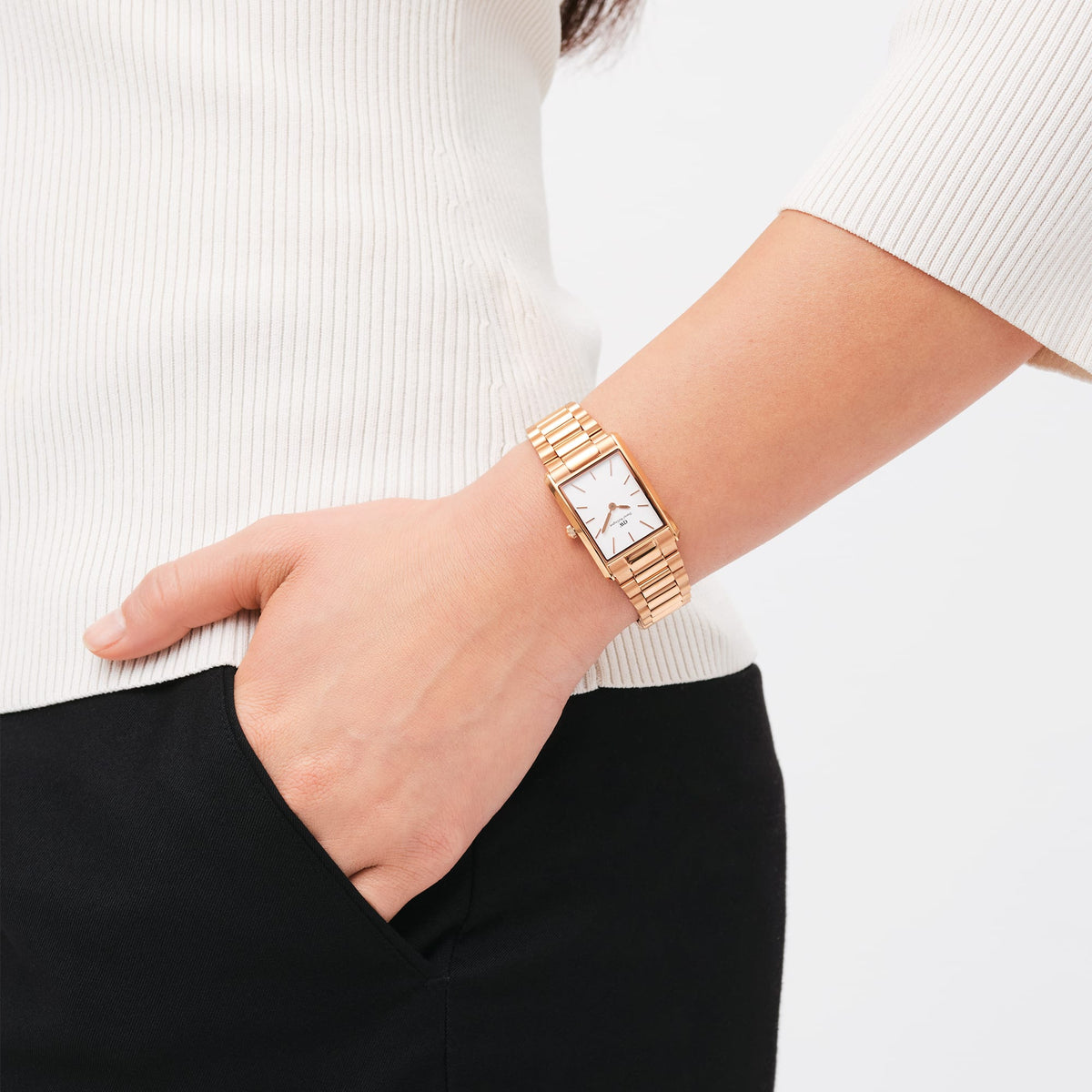 Bound 3-Link Rose Gold women's watch by Daniel Wellington with a rectangular case and 3-link rose gold bracelet, worn on the wrist and paired with an elegant outfit.