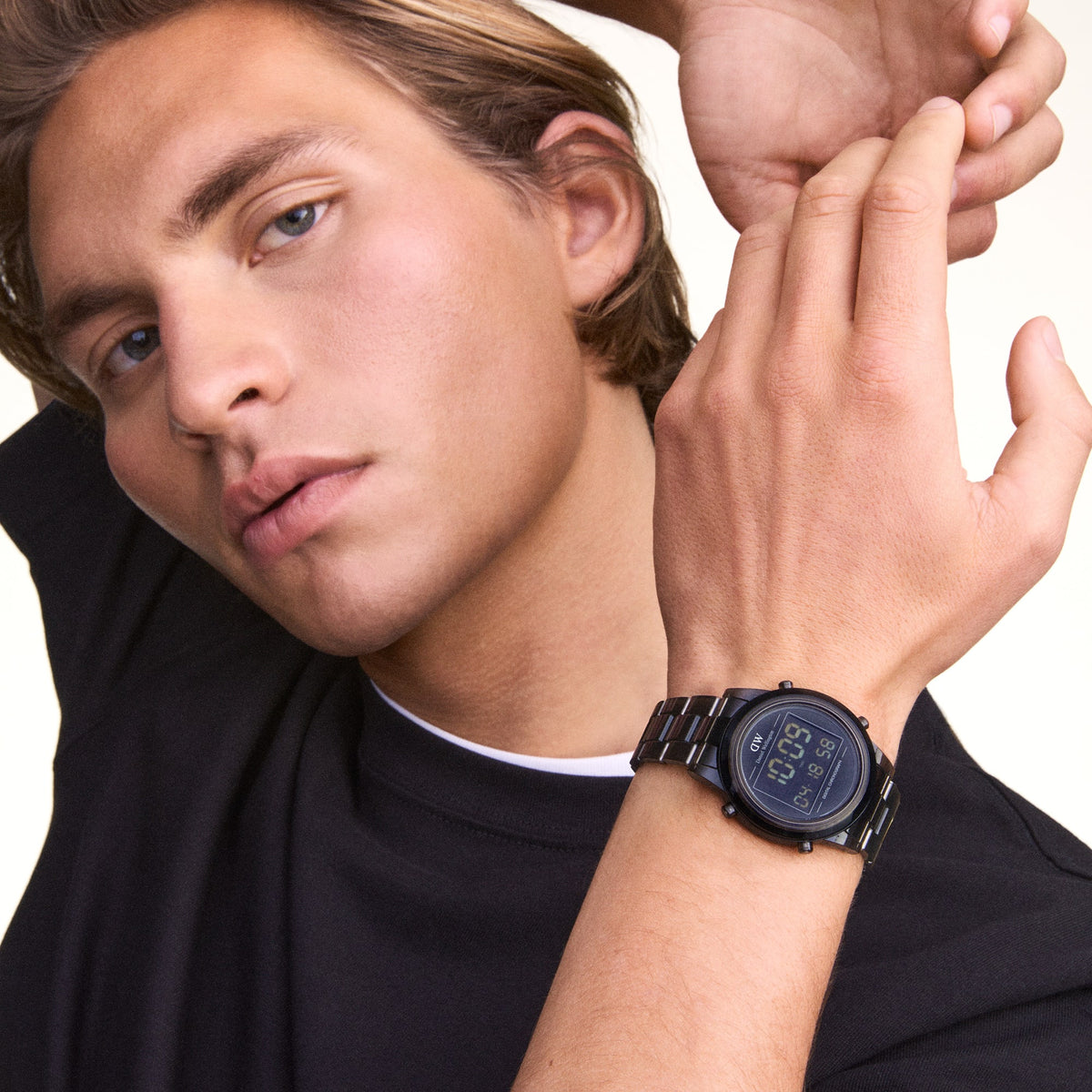 L'orologio **Retro Digital** viene indossato con la sua cassa rotonda e il cinturino a maglie in plastica bio-based, abbinato a una t-shirt nera per un look casual e minimalista.