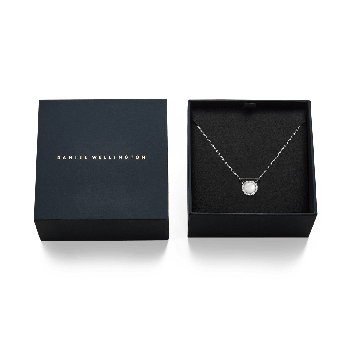 The Audrey necklace in silver with a round mother-of-pearl pendant and crystals is presented in an elegant black Daniel Wellington jewellery box.