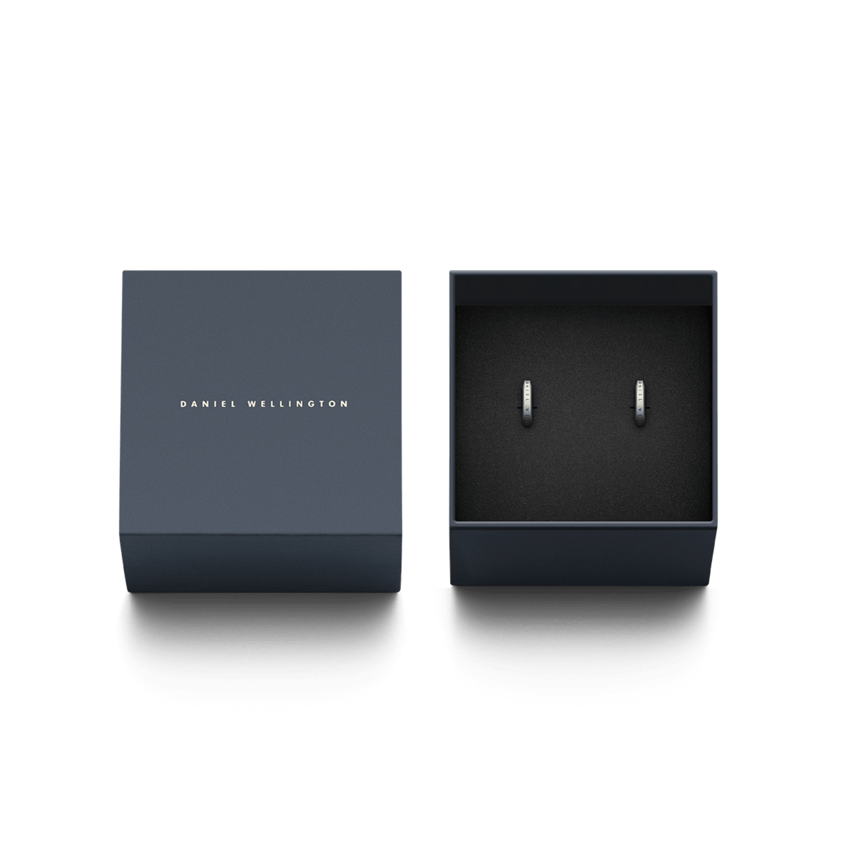 The silver Elan Earrings by Daniel Wellington are elegantly presented in a luxurious dark blue gift box with embossed logo.