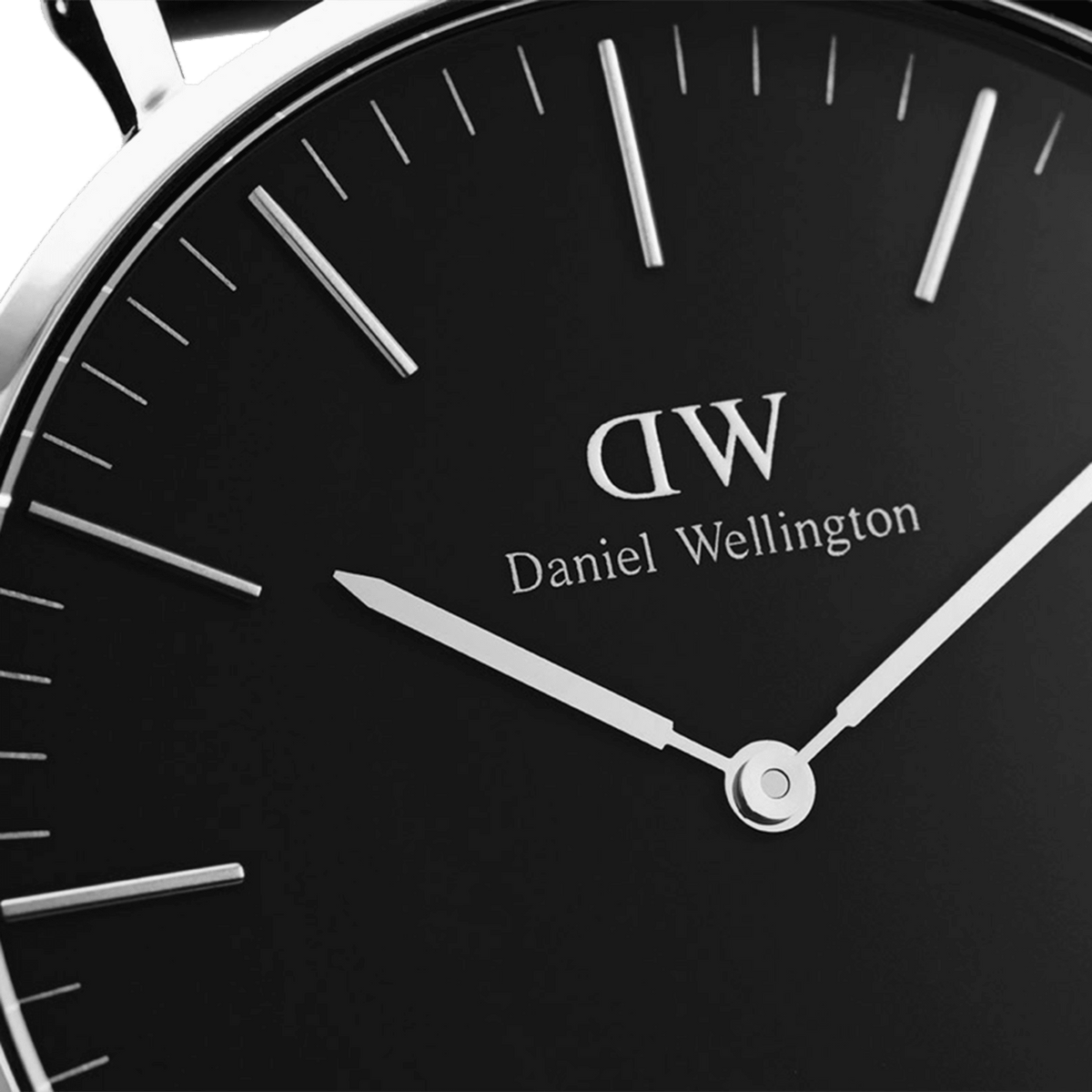 Dettaglio del quadrante nero con indici minimalisti e logo Daniel Wellington, incorniciato dalla lunetta in acciaio lucido della cassa da 36 mm.