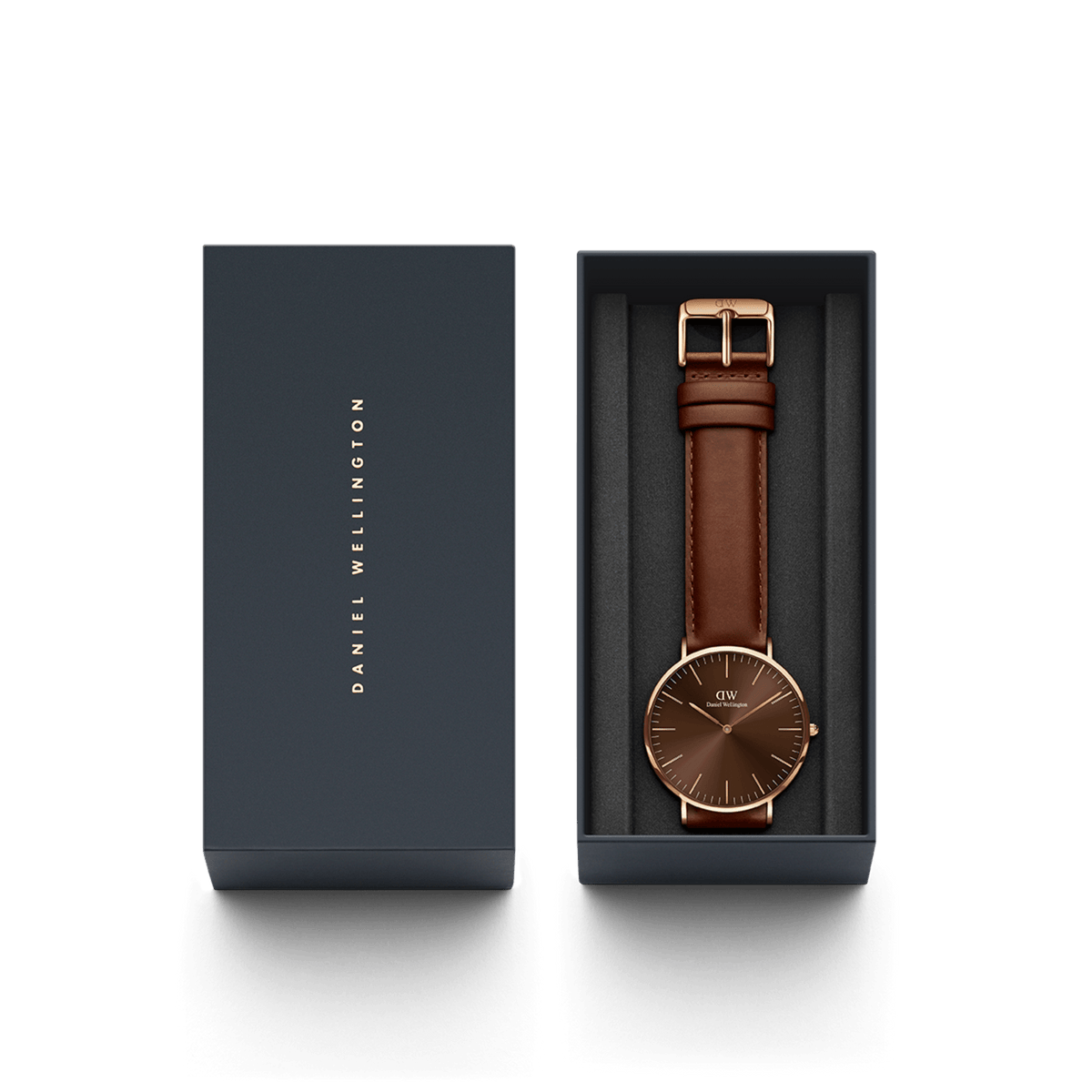 Confezione regalo Daniel Wellington contenente l'orologio Classic St Mawes Amber Rose Gold, adagiato su un cuscinetto nero all'interno di una scatola elegante con logo verticale.