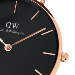 Dettaglio del quadrante nero dell'orologio Petite York di Daniel Wellington, impreziosito da lancette e indici lineari in oro rosa. Il design minimalista ed elegante valorizza la raffinatezza del modello.