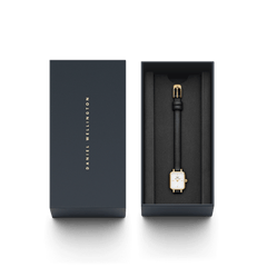 The Quadro Mini Sheffield Gold women's watch with a rectangular, gold-coloured case and black leather strap is elegantly presented in a high-quality Daniel Wellington gift box.
