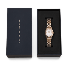 Ophelia Mini ladies' watch in rose gold with an oval case and white dial, stylishly presented in a black Daniel Wellington gift box.