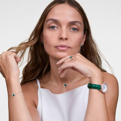Lady wearing the Crystalline Bezel Green Croc Rose Gold watch with green leather strap and sparkling bezel on her wrist, paired with matching green jewellery for an elegant look.