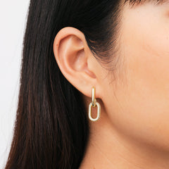 Golden Crystal Link earring with sparkling cubic zirconia crystals in a chain link design, elegantly worn on a woman's ear.