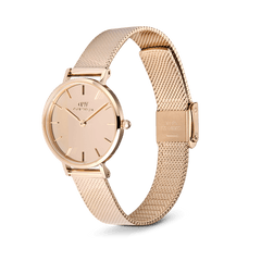 The Petite Reflection Rose Gold women's watch features a round mirrored dial, a slim 28 mm case, and a finely crafted mesh strap made of rose gold-coloured stainless steel.