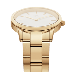 Close-up of the Daniel Wellington Iconic Link women's watch with a gold-coloured link bracelet, polished case, and white dial.